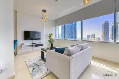 a living room with a couch and a tv at Welcoming Studio at Sky Gardens DIFC By Deluxe Holiday Homes in Dubai