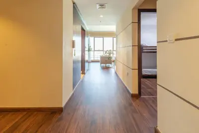 an empty room with a hallway with wood floors at FIRST CLASS 3BR with full BURJ KHALIFA VIEW in Dubai