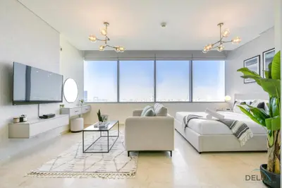 a living room with a couch and a tv at Great Deal Cozy 1BR with Pool & City Views by Deluxe Holiday Homes in Dubai