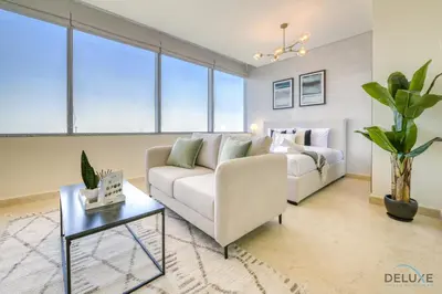 a living room with a couch and a bed at Great Deal Cozy 1BR with Pool & City Views by Deluxe Holiday Homes in Dubai