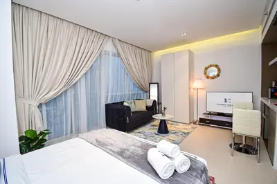 a bedroom with a bed and a large window at Luxury Escapes - Modern studio in West Avenue Dubai Marina in Dubai