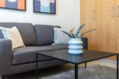a living room with a couch and a vase on a table at Silkhaus lovely studio with Downtown view in Boulevard central in Dubai