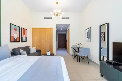 a bedroom with a large bed and a living room at Silkhaus lovely studio with Downtown view in Boulevard central in Dubai