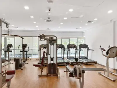 a gym with several treadmills and elliptical machines at Silkhaus with full Burj Khalifa & fountain view 1BDR in Downtown in Dubai