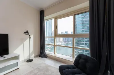 a living room with a large window and a chair at Marina Quays West, Dubai Marina - Mint Stay in Dubai