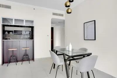 a dining room with a glass table and white chairs at Marina Quays West, Dubai Marina - Mint Stay in Dubai