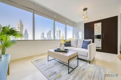 a living room with a couch and a table at Affordable Luxury Modern 1BR with Pool & Balcony by Deluxe Holiday Homes in Dubai
