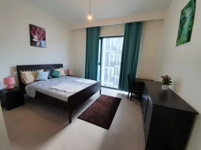 a bedroom with a bed and a large window at 2 Bedroom Apartment Available For Short Term Stay in Dubai