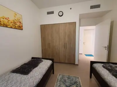 a bedroom with two beds and a wooden door at 2 Bedroom Apartment Available For Short Term Stay in Dubai