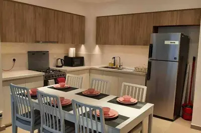 a kitchen with a table with chairs and a refrigerator at 2 Bedroom Apartment Available For Short Term Stay in Dubai