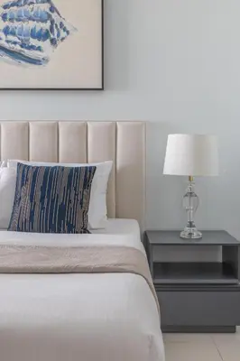 a bedroom with a bed and a nightstand with a lamp at Frank Porter - Paramount Midtown in Dubai
