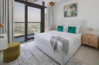 a white bedroom with a large bed and large windows at Frank Porter - Paramount Midtown in Dubai