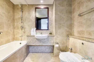 a bathroom with a tub and a sink and a toilet at Refreshing Studio at Sky Gardens DIFC by Deluxe Holiday Homes in Dubai