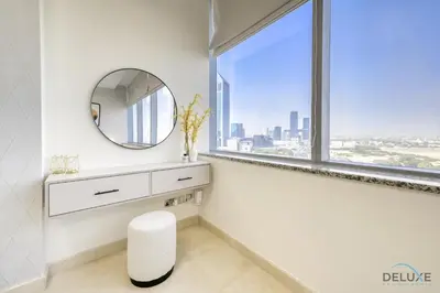 a white bathroom with a mirror and a window at Refreshing Studio at Sky Gardens DIFC by Deluxe Holiday Homes in Dubai