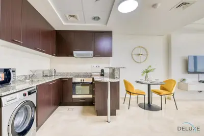 a kitchen with a washing machine and a table at Refreshing Studio at Sky Gardens DIFC by Deluxe Holiday Homes in Dubai