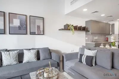 a living room with two gray couches and a kitchen at Scenic 1BR at Ocean Heights Dubai Marina by Deluxe Holiday Homes in Dubai