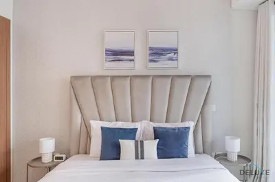 a bedroom with a large bed with blue pillows at Scenic 1BR at Ocean Heights Dubai Marina by Deluxe Holiday Homes in Dubai
