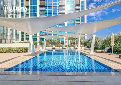 a swimming pool with a white canopy and a building at Elegant Apartment with Direct access to Dubai Mall in Dubai