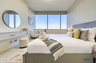 a bedroom with a large bed and a mirror at Jubilant 1BR at Sky Gardens DIFC by Deluxe Holiday Homes in Dubai