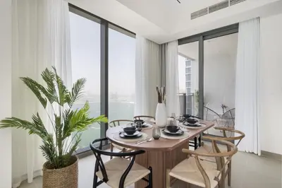 a dining room with a table and chairs and a large window at GuestReady - Luxury l Sea Views Oasis in Dubai