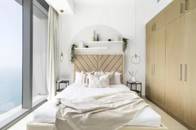 a bedroom with a large white bed with a wooden headboard at GuestReady - Luxury l Sea Views Oasis in Dubai