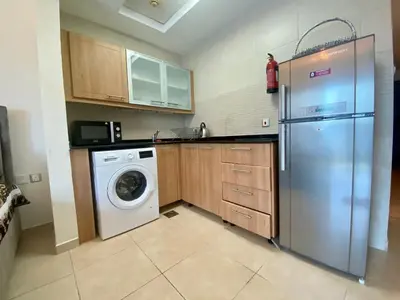 a kitchen with a refrigerator and a washing machine at Cosy Studio in Marina in Dubai