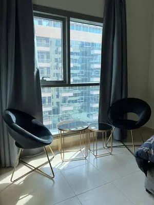 three chairs and a table in front of a window at Cosy Studio in Marina in Dubai