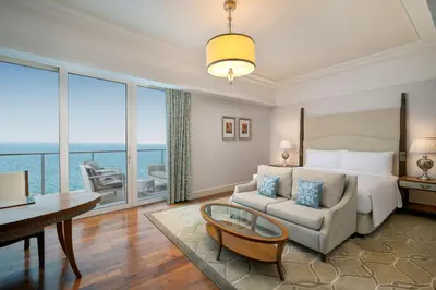 a bedroom with a bed and a table and a couch at Waldorf Astoria Dubai Palm Jumeirah in Dubai