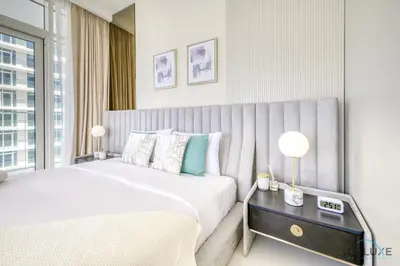 a bedroom with a large white bed and a window at Exotic 2BR at Sunrise Bay Tower 1 Emaar Beachfront Dubai Marina by Deluxe Holiday Homes in Dubai