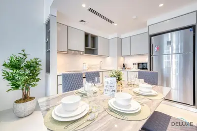 a kitchen and dining room with a table with dishes at Exotic 2BR at Sunrise Bay Tower 1 Emaar Beachfront Dubai Marina by Deluxe Holiday Homes in Dubai