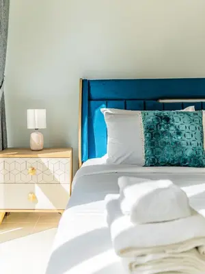 a bedroom with a bed with a blue headboard at Glamorous Apartment Facing Burj Khalifa in Dubai