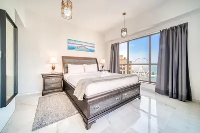 a bedroom with a bed and a large window at 300m From The Beach - JBR Apartment with Sea & Dubai Eye Views in Dubai