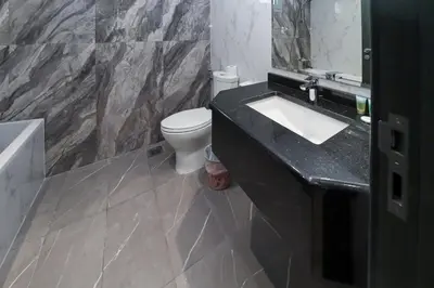 a bathroom with a white toilet and a sink at Spacious 4BR En-Suite Apt I Gym, Pool & Parking in Dubai