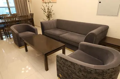 a living room with a couch and a table and chairs at Cozy Family Apt Canal Vista Near Dubai Mall in Dubai