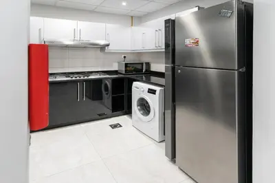a kitchen with a refrigerator and a washer and dryer at Cozy Family Apt Canal Vista Near Dubai Mall in Dubai