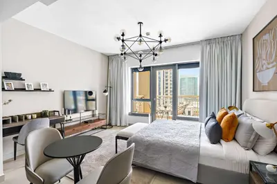 a bedroom with a bed and a living room at Silkhaus cozy central studio in Downtown in 29 Boulevard in Dubai