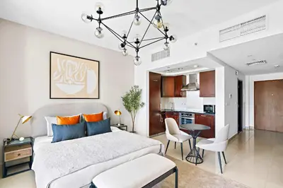 a bedroom with a large bed and a kitchen at Silkhaus cozy central studio in Downtown in 29 Boulevard in Dubai