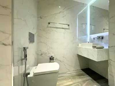 a white bathroom with a toilet and a sink at STYLISH 2 BEDROOM SERVICE APARTMENT with SEA VIEW in Dubai