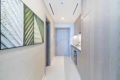 a hallway leading to a kitchen with a painting on the wall at The Smart Concierge - Palm tower in Dubai