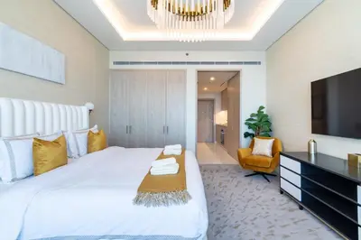 a bedroom with a large white bed and a tv at The Smart Concierge - Palm tower in Dubai