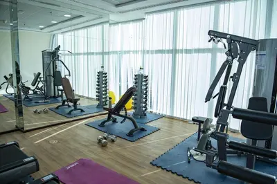 a gym with several treadmills and elliptical machines at Studio in the heart of Sports City -great view & amenities! in Dubai