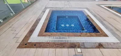 a swimming pool with blue tiles on a wooden floor at Urban 1BR at Binghatti Stars Dubai Silicon Oasis by Deluxe Holiday Homes in Dubai