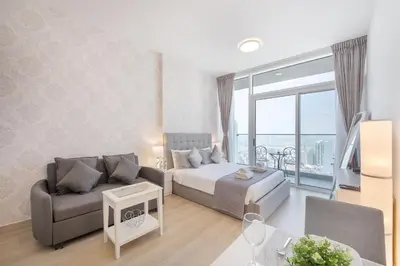 a bedroom with a bed and a couch and a table at Apartment on 26th Floor & Beautiful Views (2 adults + 2 kids) in Dubai