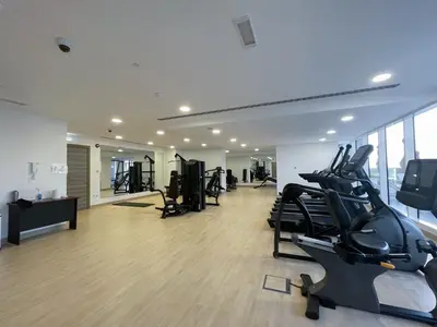 a gym with treadmills and ellipticals in a building at Apartment on 26th Floor & Beautiful Views (2 adults + 2 kids) in Dubai