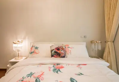 a bedroom with a white bed with floral pillows at Luxurious 2BR - Fully Upgraded - High-end facilities in Dubai