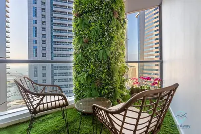 a balcony with two chairs and a green wall at Modern 2BR in the Heart of Dubai Marina in Dubai