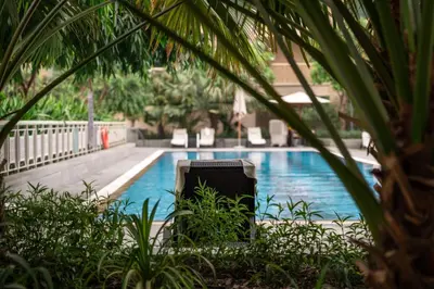 a briefcase sitting in front of a swimming pool at Prime Retreats - 29 Emaar Boulevard Downtown Dubai in Dubai