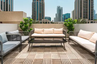 a patio with two couches and a table on a roof at Prime Retreats - 29 Emaar Boulevard Downtown Dubai in Dubai