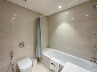 a bathroom with a tub and a toilet and a sink at HiGuests - Superlative apt with private beach access in Dubai