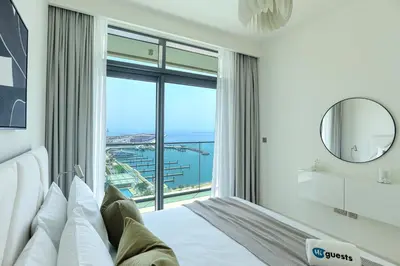 a bedroom with a bed and a large window at HiGuests - Superlative apt with private beach access in Dubai